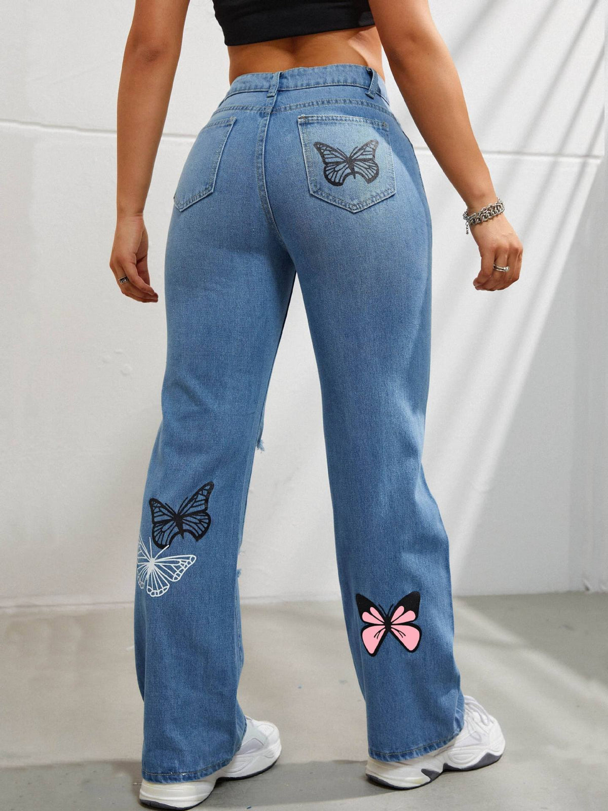 High-waisted straight leg jeans with butterfly print and rips
