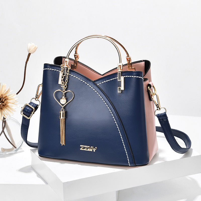 Colour block handbag with heart tassel