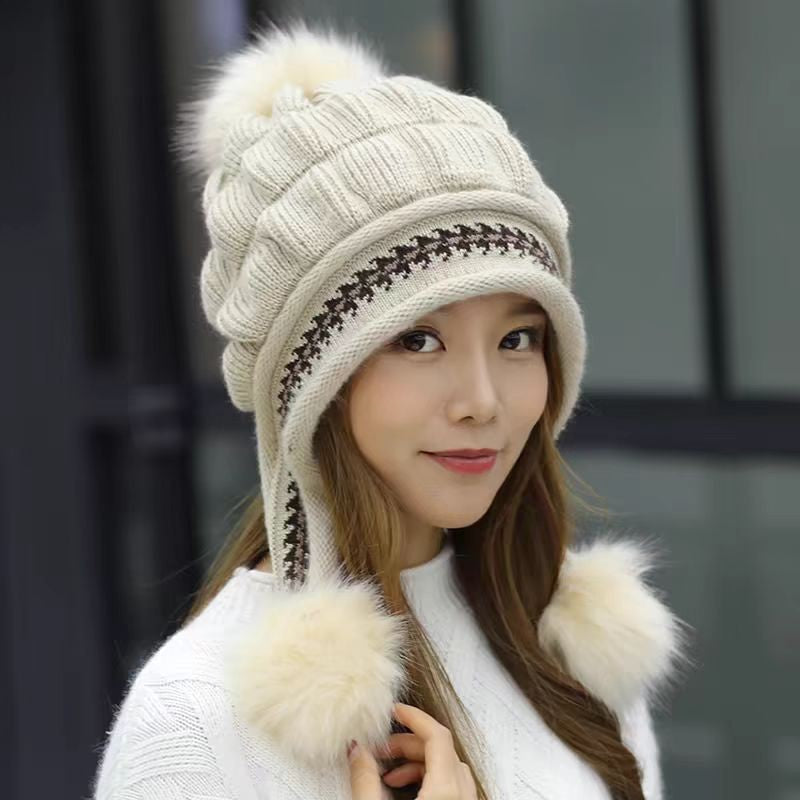 Woman in a knitted bobble hat with ear flaps
